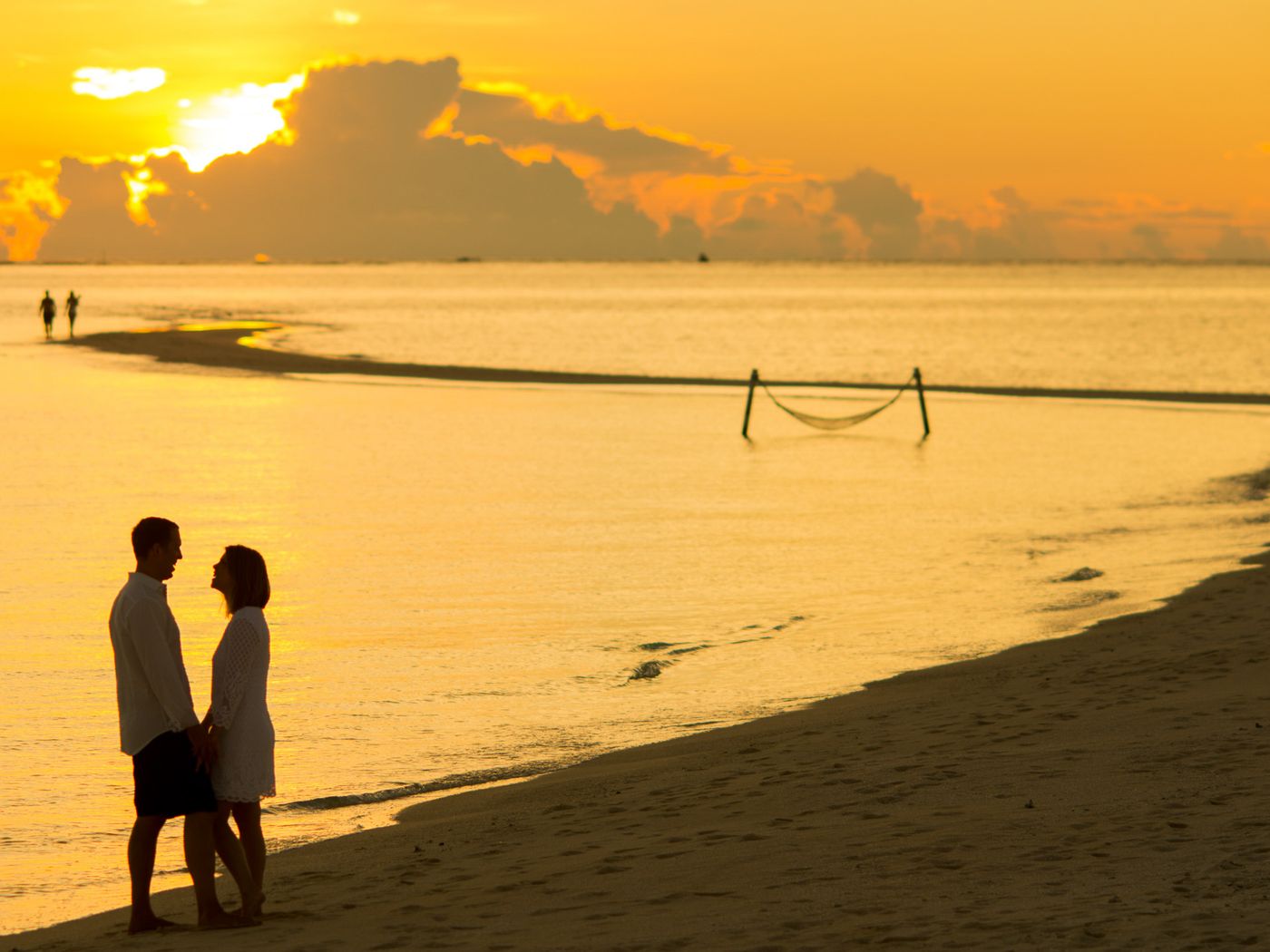 Couple on tropical beach at sunset