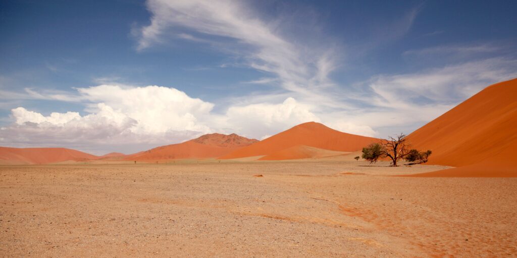 Red sand dunes of the Namib Desert under blue sky