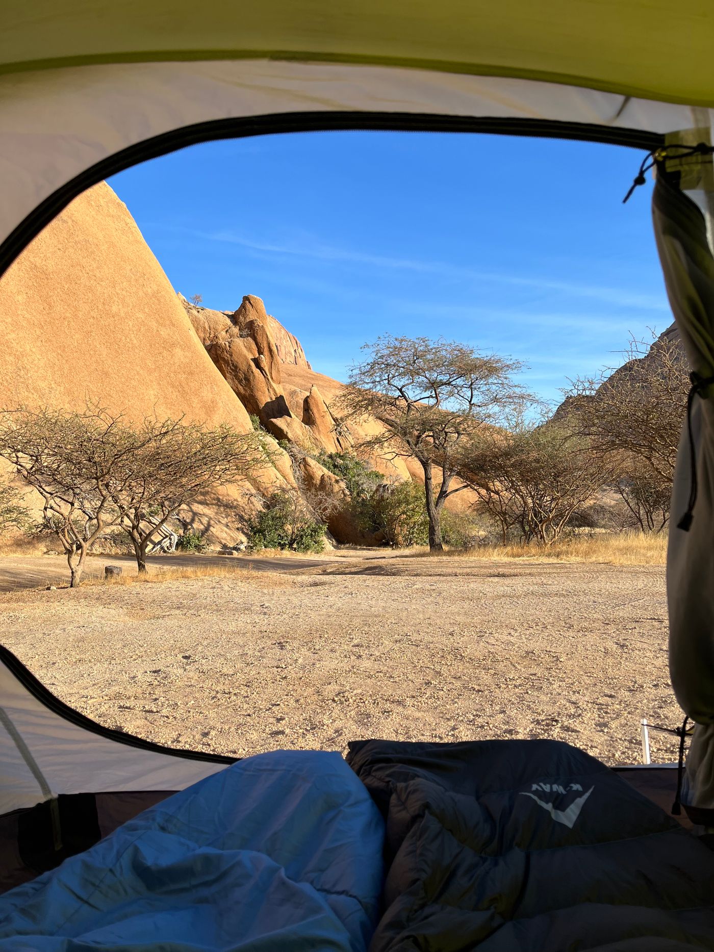 Campsite view through tent toward landscape